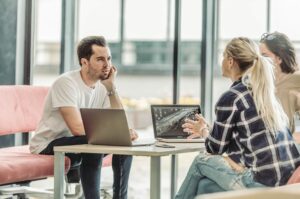 Hvad er god E-Learning? Kolleger taler ved et bord.
