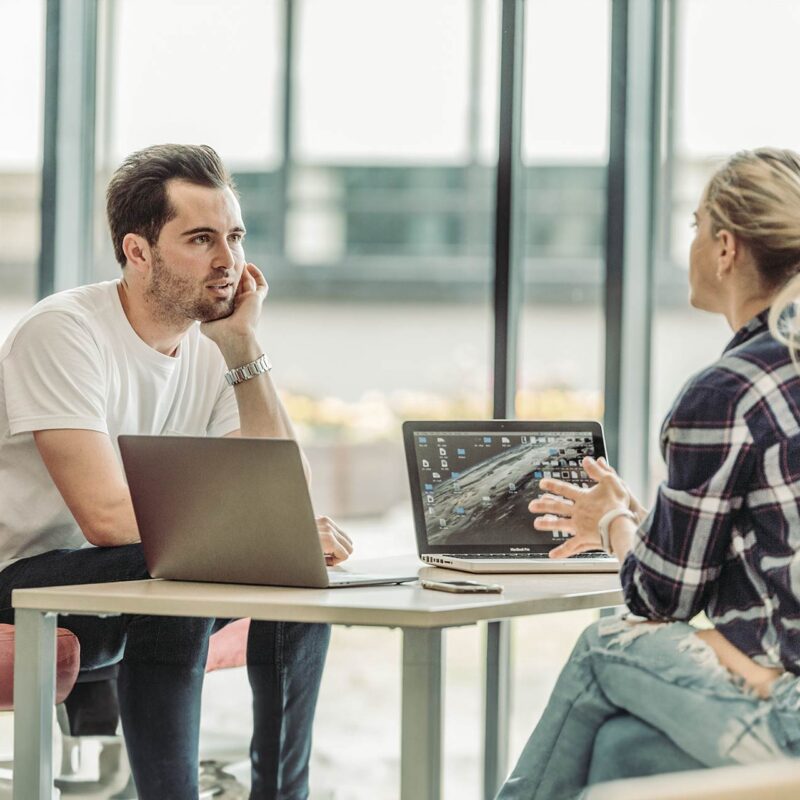 Hvad er god E-Learning? Kolleger taler ved et bord.