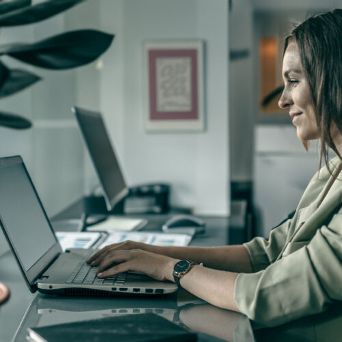 Kvinde arbejder med Systemtræning og E-Learning på bærebar computer.