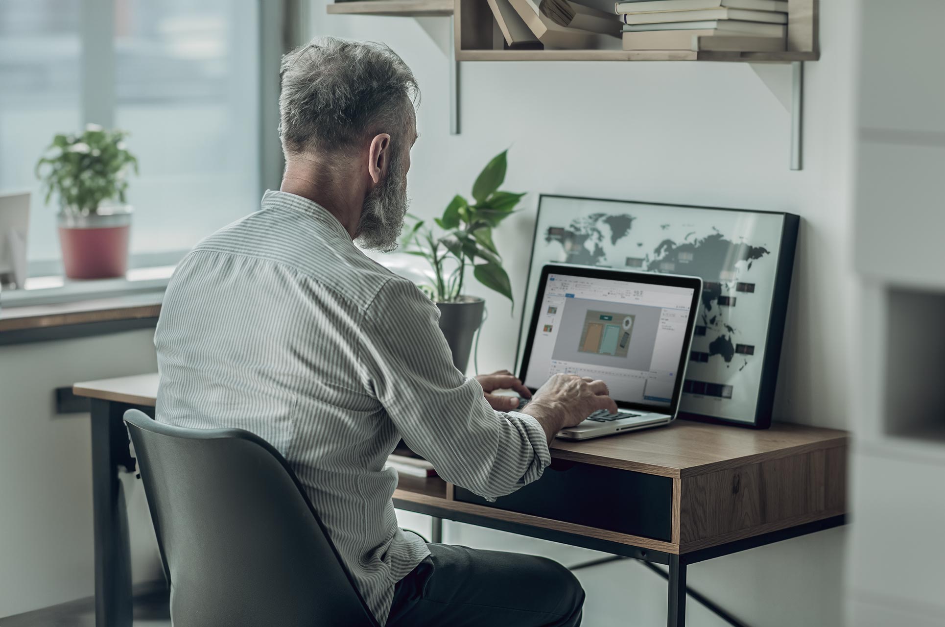 Blogpost om Articulate Storyline. Man sidder på hjemmekontor og arbejder.