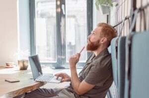 5 gode grunde til at anvende E-Learning. Mand undrer sig ved computer.