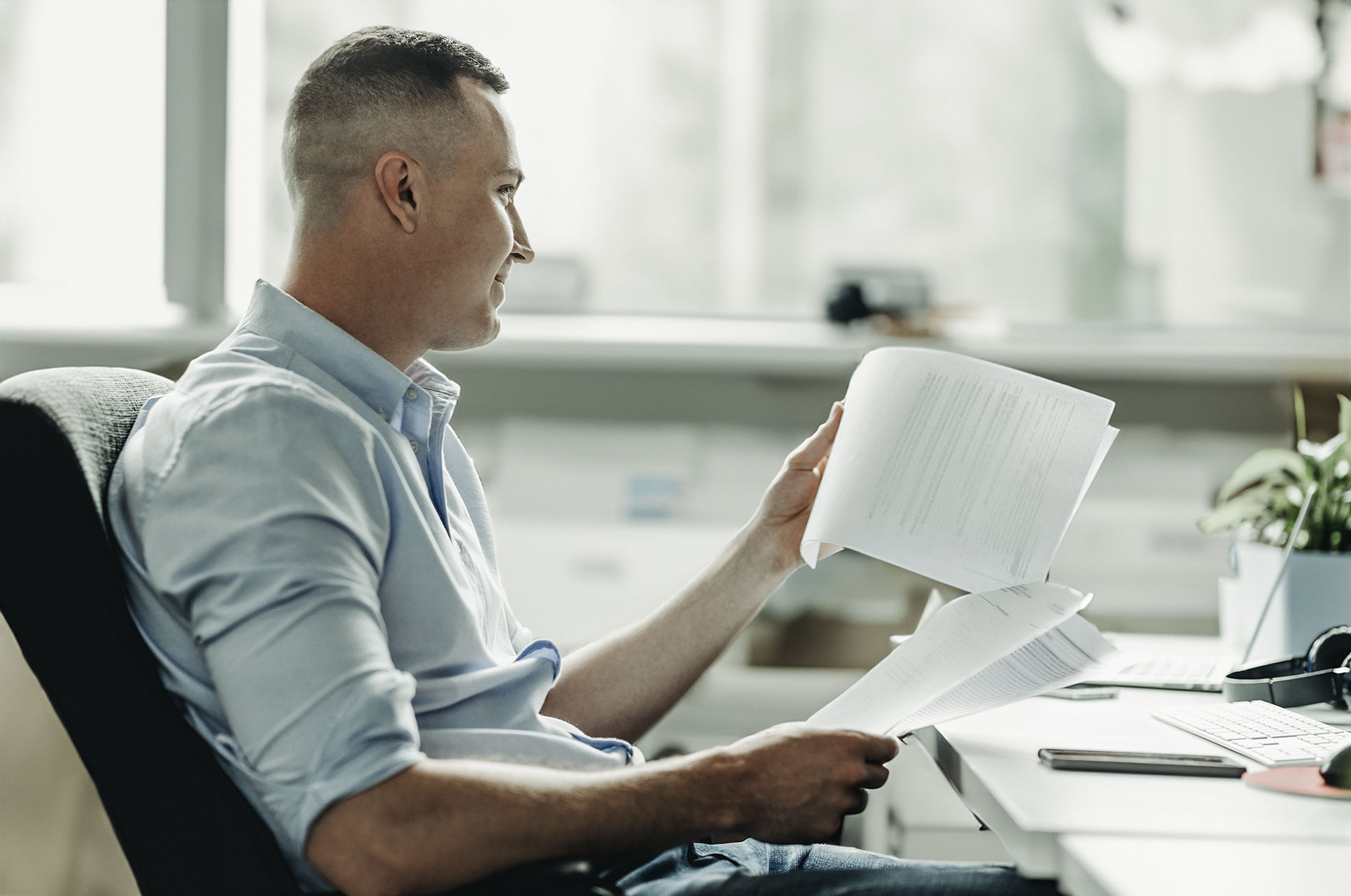 Online course GDPR. Male looking at paper and computer