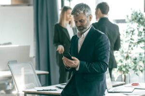 Business executive looking at phone during break from meeting