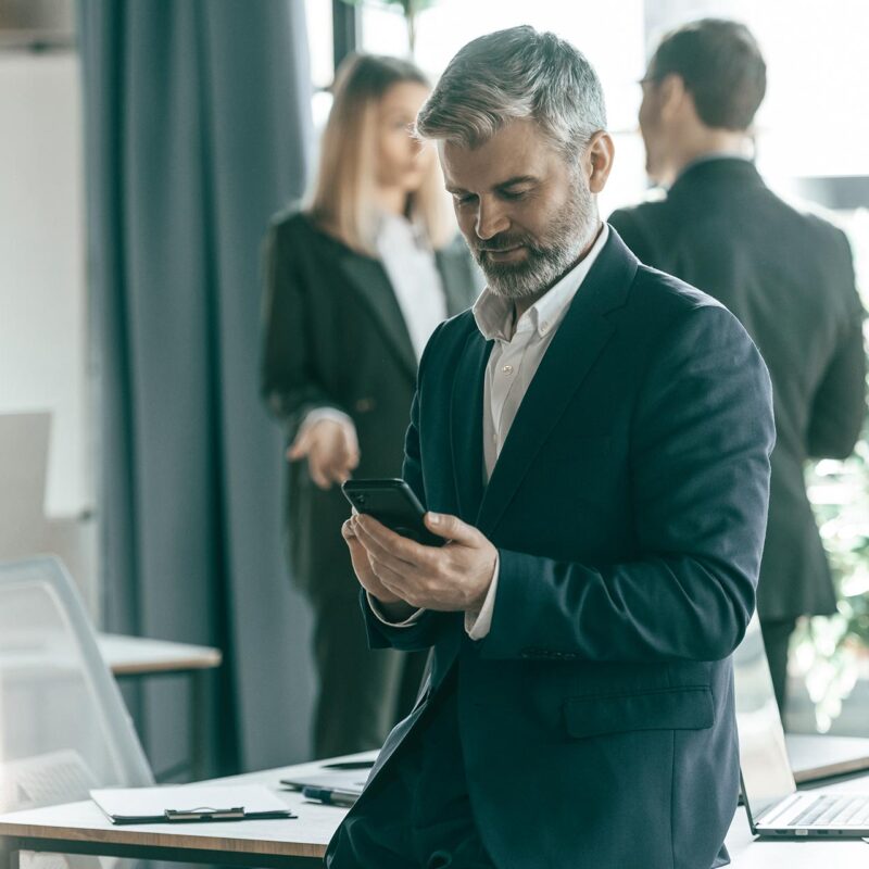 Business executive looking at phone during break from meeting