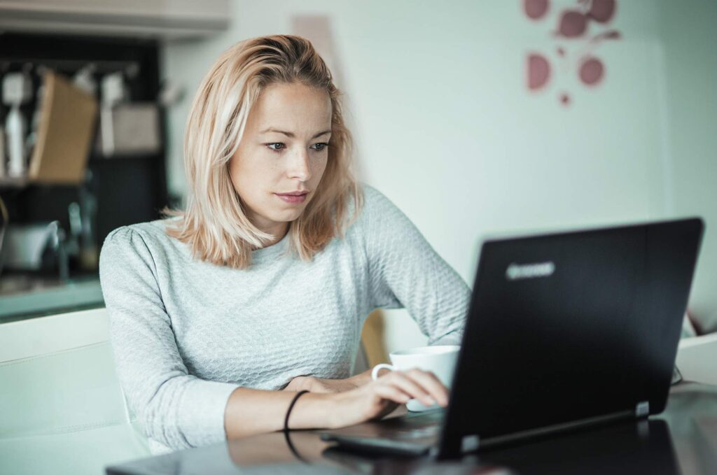 Kvinde bruger bærbar computer og deltager i AI awareness online kursus